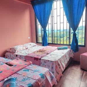 a bedroom with two twin beds and a window at ApartaHotel El Balcón del Tolima in Falan