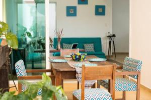 a dining room with a table and chairs and a couch at CASA MINERVA MERIDA in Mérida