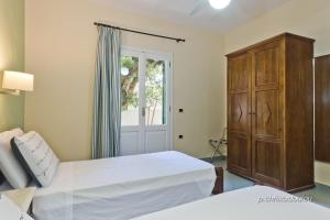 1 dormitorio con 2 camas, vestidor y ventana en Rigò Apartments, en Kyra Panagia