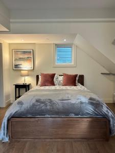 una camera da letto con un grande letto con due cuscini di Vineyard Suite at The Inn On The Drive a Vancouver