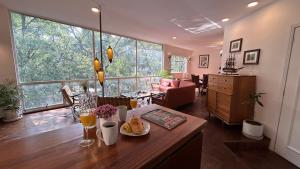 a living room with a table and a large window at Edificio Art Deco en Roma Norte in Mexico City