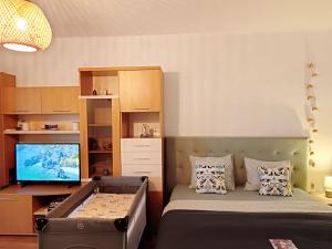 a bedroom with a bed and a desk with a television at Sunrise Beachfront Relax Studio in Constanţa