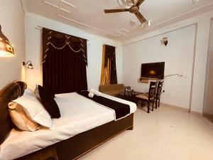 a bedroom with a bed and a desk and a television at The For U - A Luxury Stay in Rishīkesh