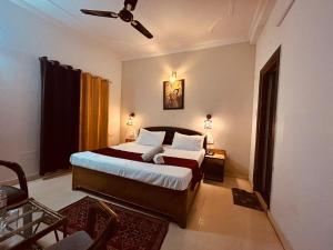 The For U - A Luxury Stay في ريشيكيش: غرفة نوم بسرير ومروحة سقف