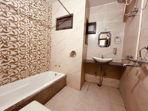 een badkamer met een bad, een wastafel en een bad bij The For U - A Luxury Stay in Rishīkesh
