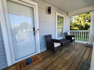 a porch with two chairs and a sliding glass door at The Grey Escape-Close to Beach Waterpark & Casinos in Atlantic City