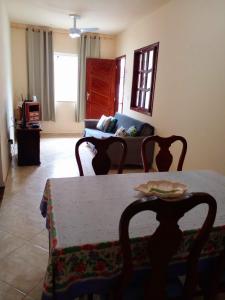 sala de estar con mesa y sofá en Caminho da Praia - Casa e kitnet en Arraial do Cabo