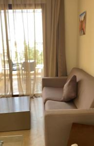 uma sala de estar com um sofá e uma grande janela em Vizir-Private Family em Marrakech