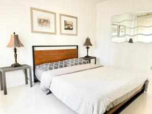 a white bedroom with a bed and two lamps at 2 BEDROOM ON THE BEACH ! in Miami Beach