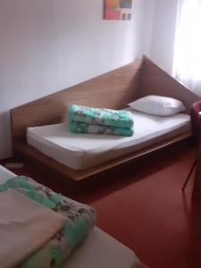 Una cama con dos toallas verdes encima. en Hanul Anitei La paducel 