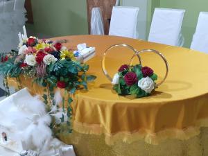 una mesa amarilla con flores y un anillo en ella en Hanul Anitei La paducel 
