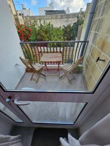 a patio with a table and chairs on a balcony at Iris -Paola Modern Townhouse in Paola