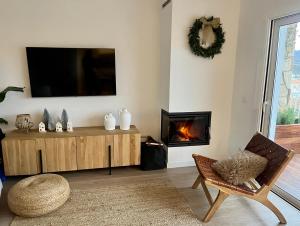 uma sala de estar com televisão e lareira em Seaport Llançà em Llançà