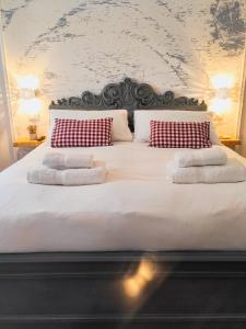 ein großes Bett mit weißer Bettwäsche und roten und weißen Kissen in der Unterkunft Annamaria Rooms in Neapel