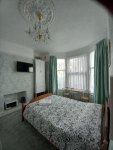 een slaapkamer met een bed en een kroonluchter bij Mari London room for holiday in Ilford