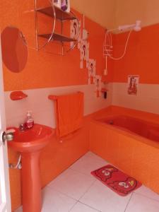 a bathroom with a red sink and a bath tub at Amalfi's Place in Pimentel