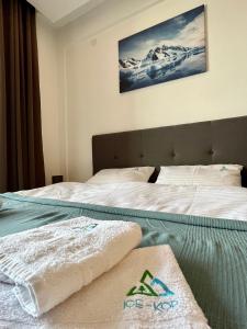 a hotel room with a bed with towels on it at ICE-KOP Milmari in Kopaonik