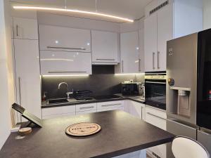 a kitchen with white cabinets and a counter top at Urban Loft in Salgótarján