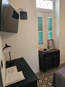 Pokój ze stołem z lampką i oknem w obiekcie Dahlia apartment - Paola Modern Townhouse w mieście Paola