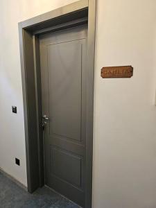a door in a room with a sign on it at Dahlia apartment - Paola Modern Townhouse in Paola