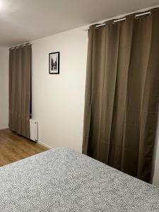 - une chambre avec des rideaux gris et un lit dans l'établissement Wauters 77 Bruxelles -charleroi-airport, à Charleroi