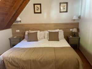 a bedroom with a large bed with two night stands at Hostal Escuils in Unha