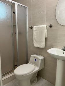 ein Badezimmer mit Toilette, Waschbecken und Dusche in der Unterkunft HOTEL BLUE COSTA Panama in Panama-Stadt