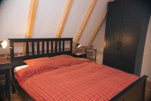 um quarto com uma cama com um cobertor xadrez vermelho em Hills em Travnik