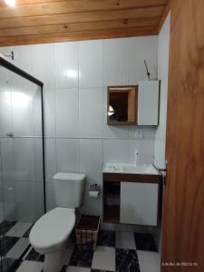 a white bathroom with a toilet and a sink at Pousada Floresta Das Estrelas in Urubici