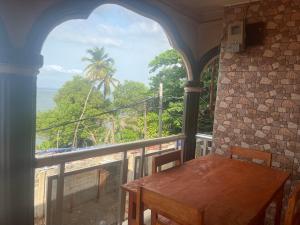 a balcony with a table and a view of the ocean at Pearson Street in Freetown