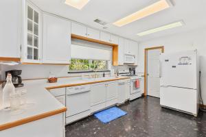 een keuken met witte kasten en een witte koelkast bij Astonishing Flagstaff Flat with AC and Jacuzzi! in Flagstaff