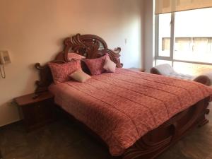 1 dormitorio con 1 cama grande y edredón rojo en Gran departamento completamente amoblado en Quito