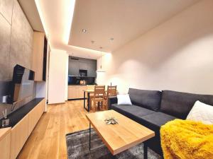 a living room with a couch and a table at Apartman Vuk, Apart hotel Zlatni javor in Jahorina