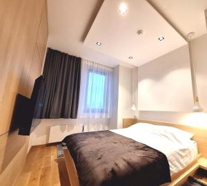 a bedroom with a large bed and a window at Apartman Vuk, Apart hotel Zlatni javor in Jahorina