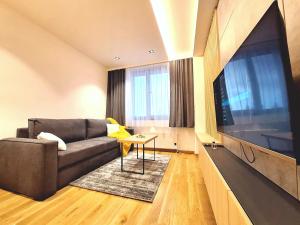 a living room with a couch and a large flat screen tv at Apartman Vuk, Apart hotel Zlatni javor in Jahorina