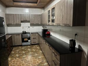 a kitchen with wooden cabinets and a black counter top at Charming 4-Bed House in Kigali in Kigali