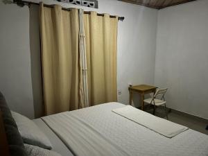 a bedroom with a bed and a table with a chair at House - Sleeps 8 - Parking - Garden in Kigali