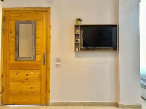 a flat screen tv on a wall next to a door at Ayana Hotel Dahab in Dahab