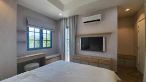 a bedroom with a bed and a flat screen tv at Villa NovawoRld Phan Thiết in Bình Sum +54 photos