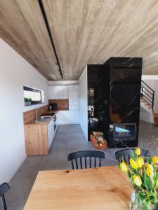a kitchen and living room with a table and a fireplace at Sosnowe Zacisze in Sasino