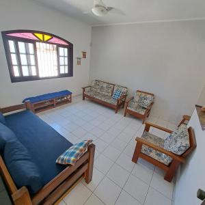 a living room with a blue couch and chairs at CASA DE PRAIA MARAVILHOSA PERUIBE in Peruíbe