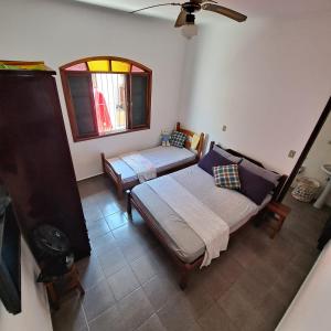 1 dormitorio con 2 camas y ventana en CASA DE PRAIA MARAVILHOSA PERUIBE, en Peruíbe