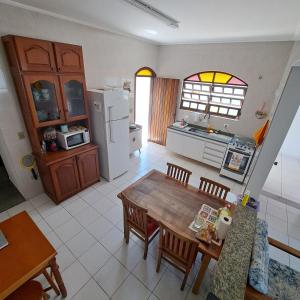 uma cozinha com uma mesa e cadeiras e um frigorífico em CASA DE PRAIA MARAVILHOSA PERUIBE em Peruíbe