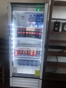 a refrigerator filled with bottles of water and soda at Pied a Terre in Paramaribo