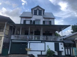 Casa blanca grande con balcón en la parte superior. en Pied a Terre, en Paramaribo