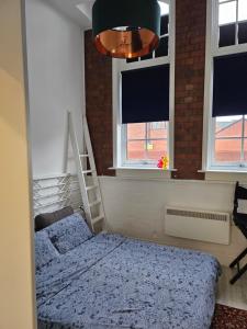 a bedroom with a bed and two windows at Characteristic loft style apartment in Birmingham