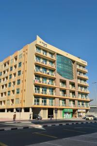 a large apartment building on a city street at Beautiful Bedroom in Al Barsha Near Mashreq Metro in Dubai