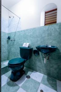 y baño con aseo azul y lavamanos. en Hotel Italia II, en Chiclayo