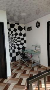 a room with a table and a checkered wall at Hospedaje Villa Salome in Pereira