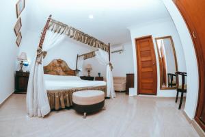 a bedroom with a large bed with a canopy at Baluarte Cartagena Hotel Boutique in Cartagena de Indias